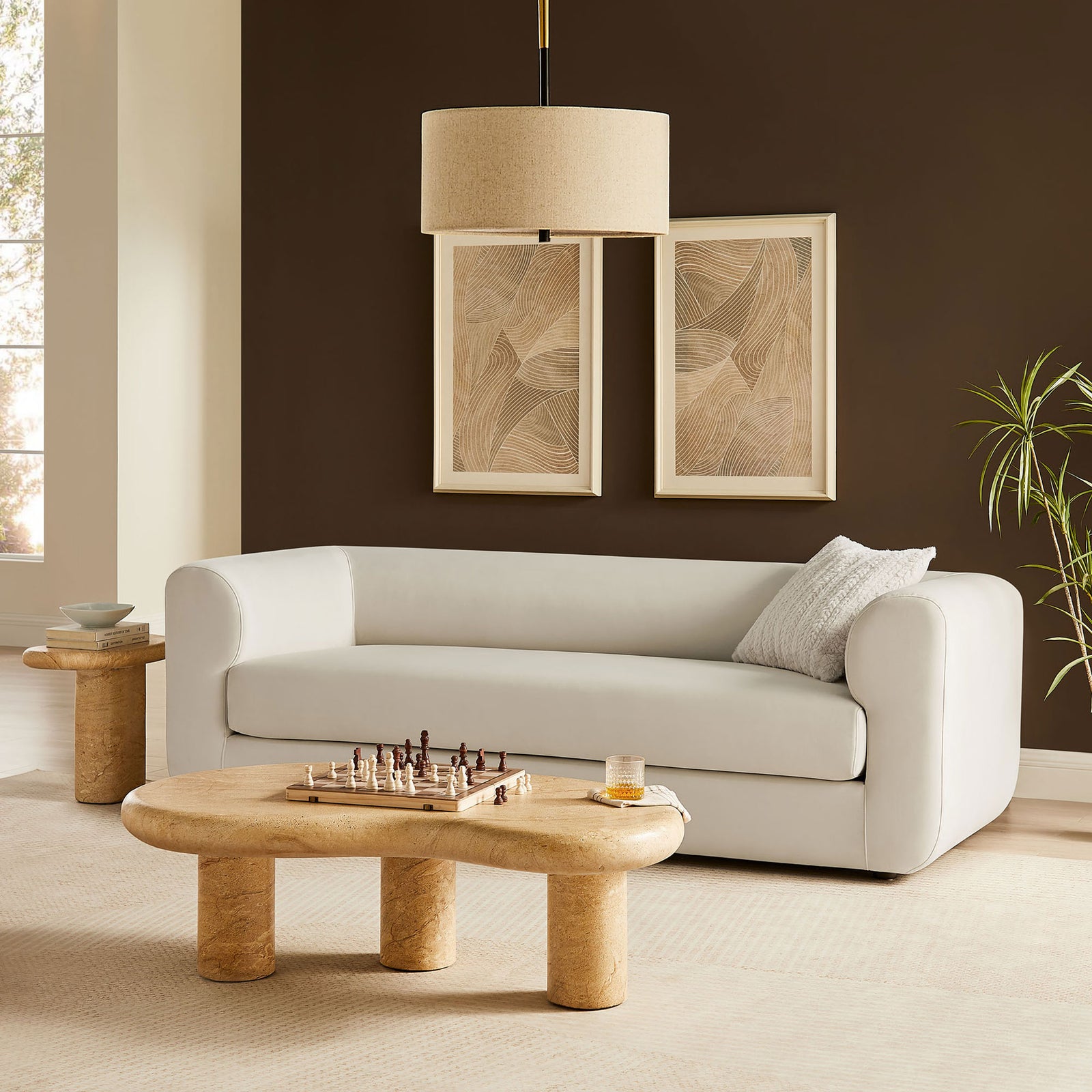 Alabaster velvet sofa anchors a warm contemporary living room with sculptural tables, wall art, and greenery || EEI-7281-ALA || front_room