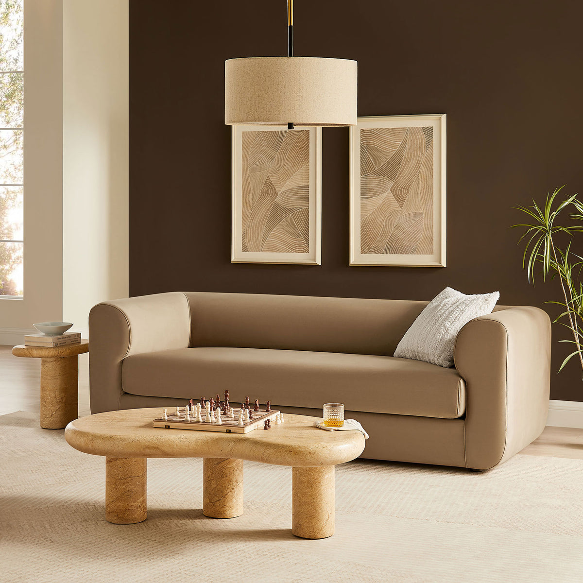 Taupe performance velvet sofa anchors a modern living room with sculptural tables and warm layered textures || EEI-7281-TAU || front_angle_room