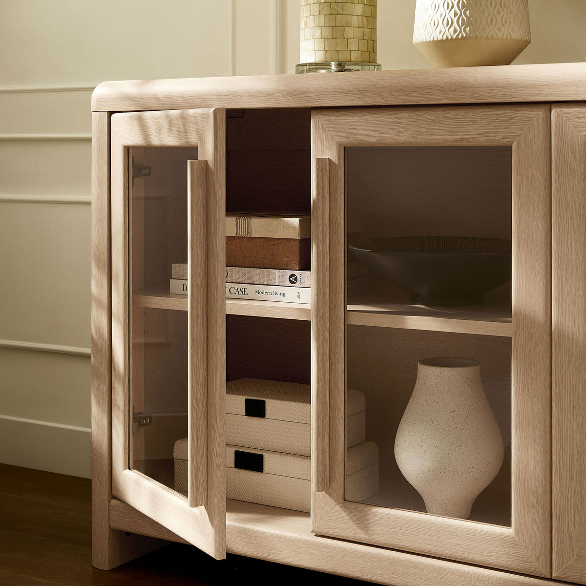 Styled Evren sideboard shelf space with glass doors open to display books, boxes, and decor. || EEI-7287-ASH || storage_open_room