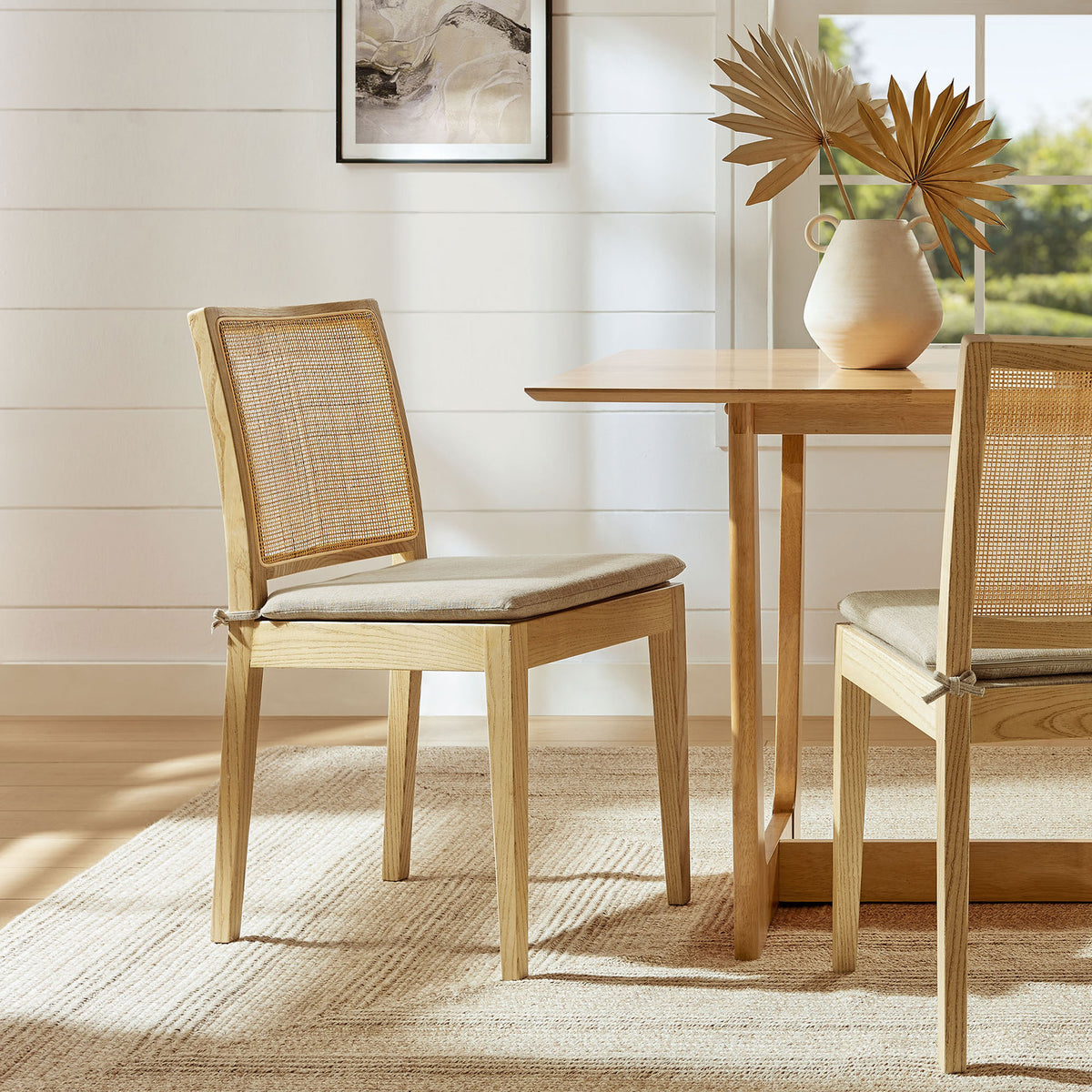 Ovard wood and rattan dining chair styled with a matching table and rug for a relaxed modern coastal dining nook || EEI-7288-NAT-BEI || front_angle_room