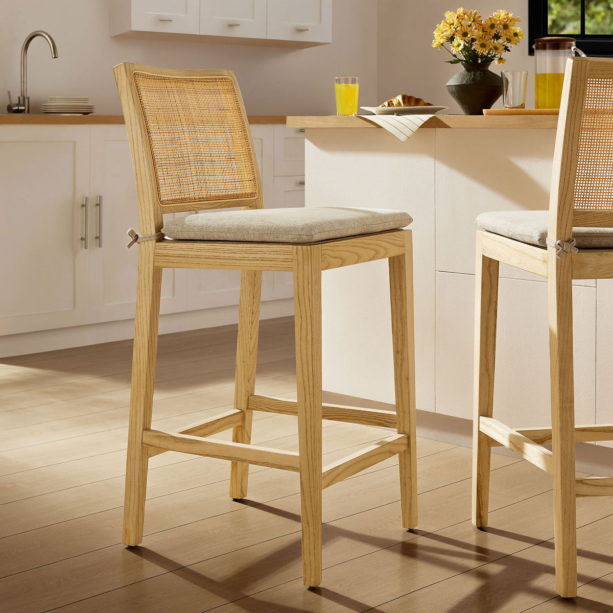 Counter stool brings airy coastal texture to the kitchen with natural wood and cane details. || EEI-7290-NAT-BEI || front_angle_room