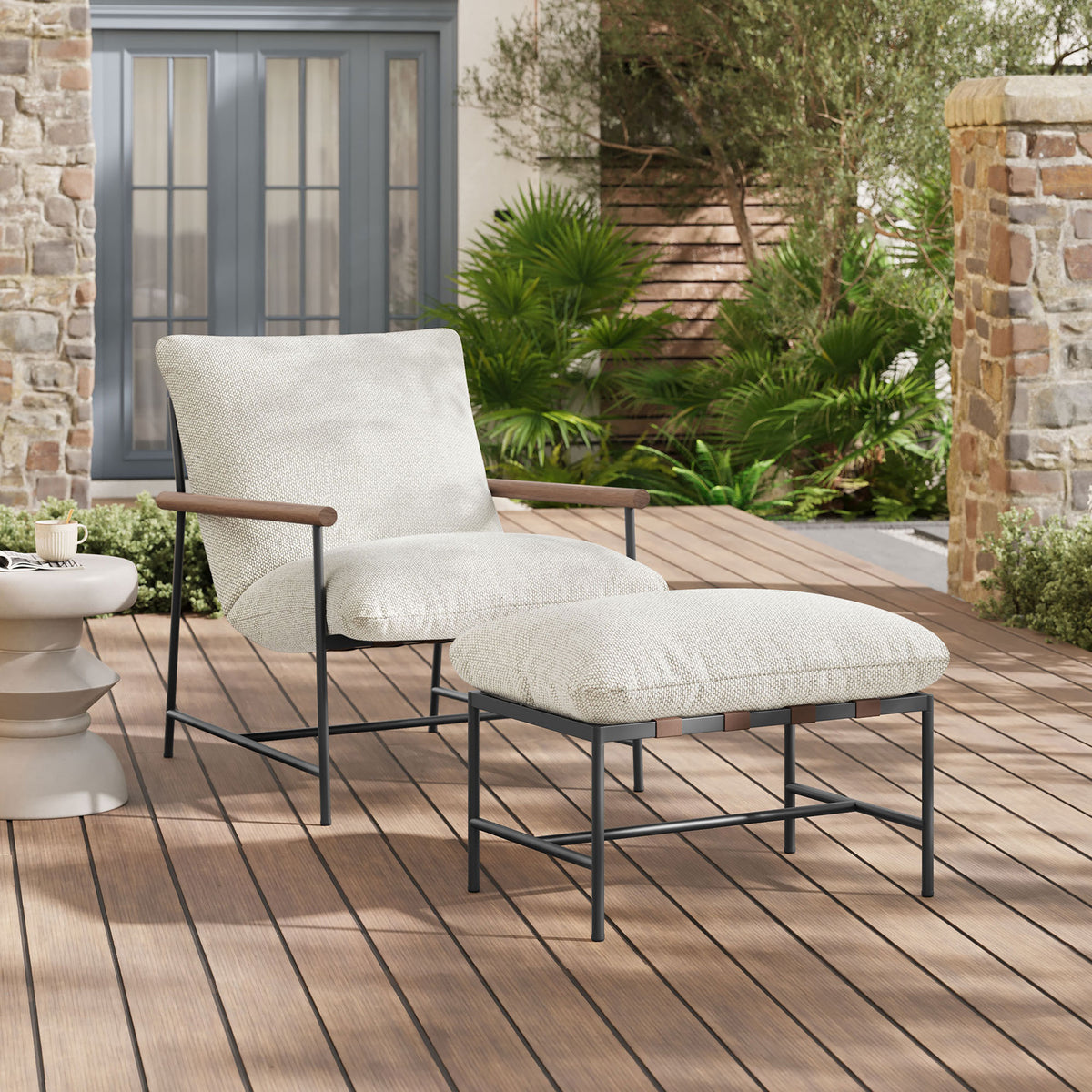 Ivory boucle lounge chair and ottoman styled on a sunlit deck with greenery and stone walls || EEI-7292-IVO || front_angle_room