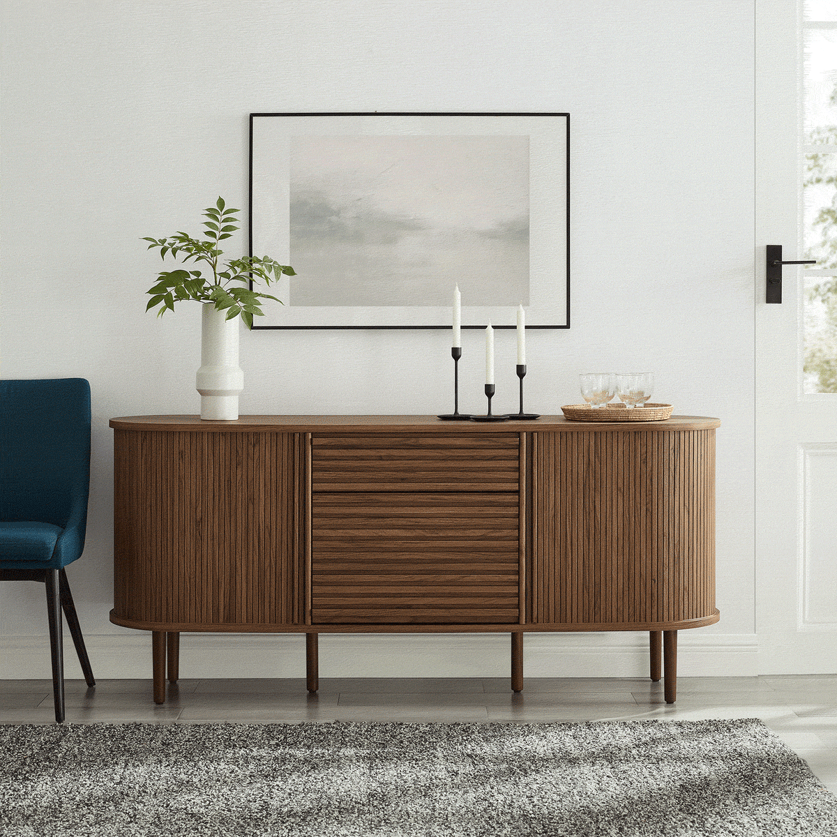 Walnut fluted sideboard styled in a bright entryway with artwork, candles, and greenery for a welcoming vignette || EEI-7293-WAL || front_angle_room