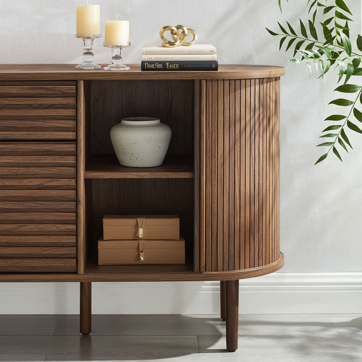 Detail of right-side shelving and fluted tambour panels with decor and boxes neatly organized inside the sideboard || EEI-7293-WAL || storage_open_room