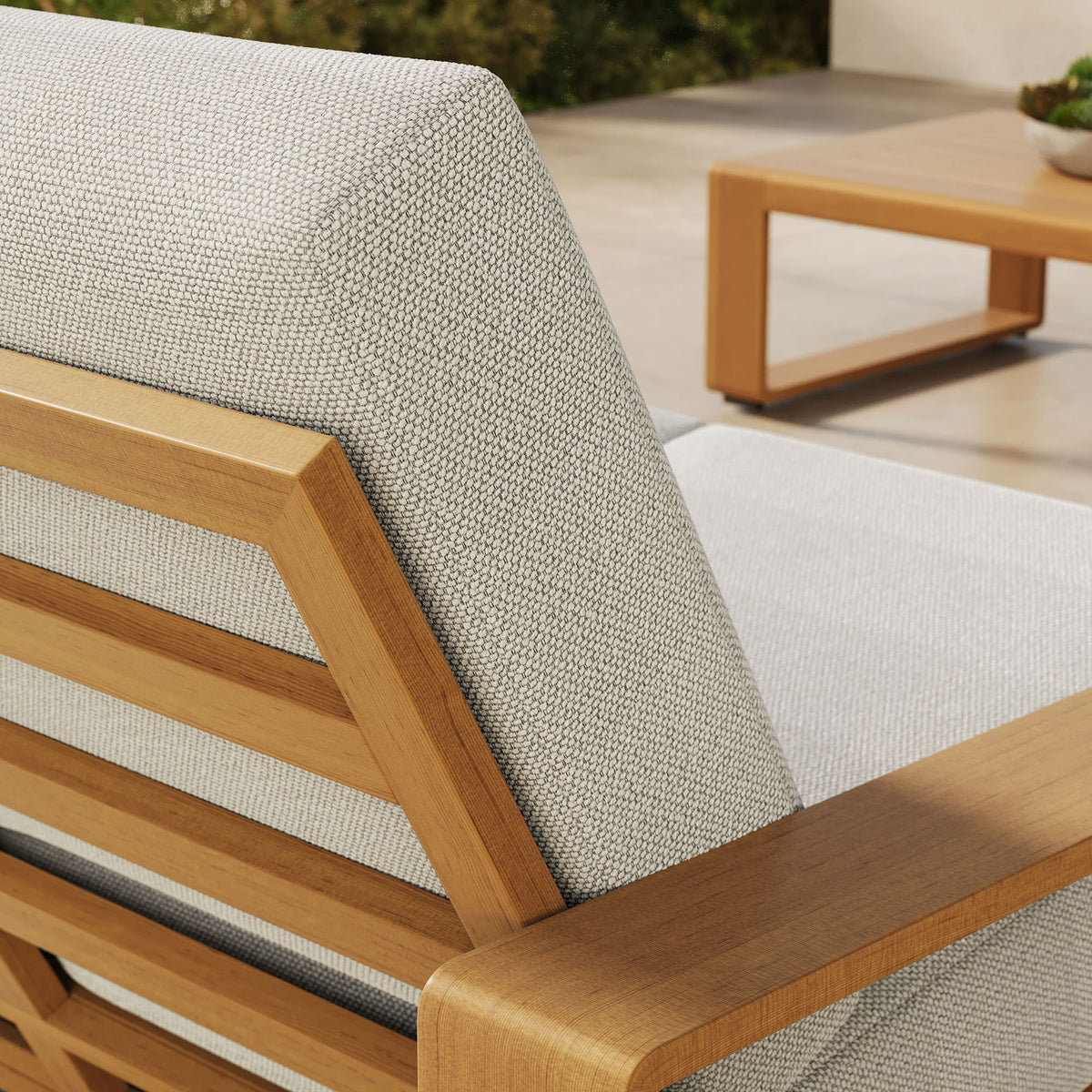 Ivory cushion and faux wood frame detail pop against the bright, sunlit terrace backdrop || EEI-7297-IVO-NAT || detail_room