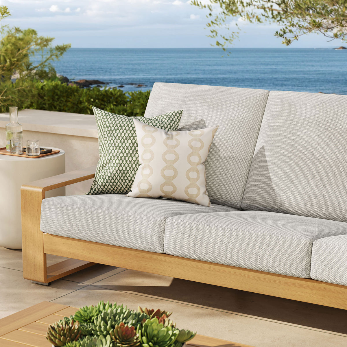 Ivory outdoor sofa with natural frame styled with accent pillows, brightening a breezy terrace setting || EEI-7298-IVO-NAT || detail_room