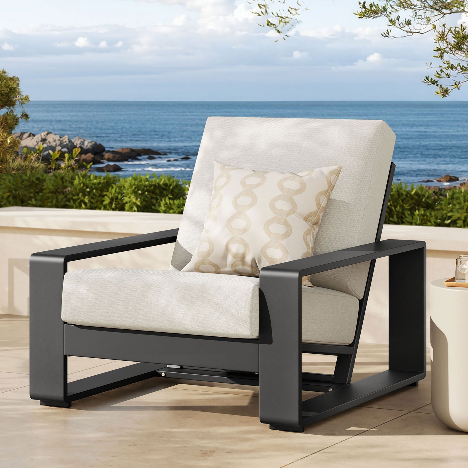 Cream and charcoal outdoor armchair creating a crisp focal point on a sunlit coastal patio || EEI-7300-CRE-GRY || front_angle_room