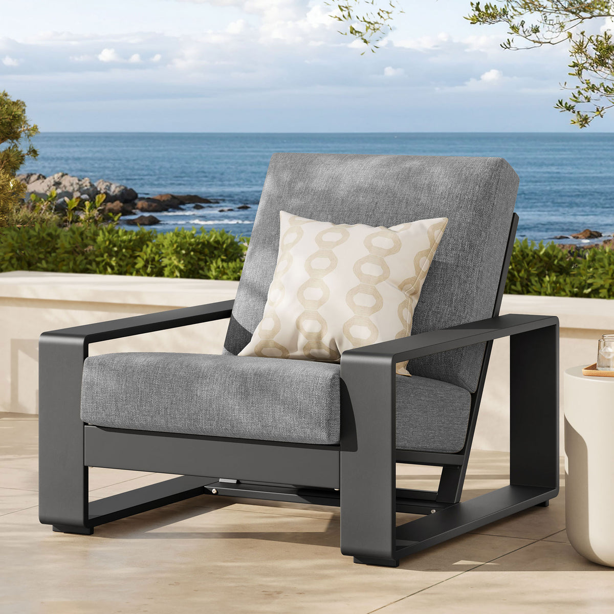 Light gray and charcoal outdoor armchair adding a modern focal point to a breezy coastal patio || EEI-7300-LGR-GRY || front_angle_room