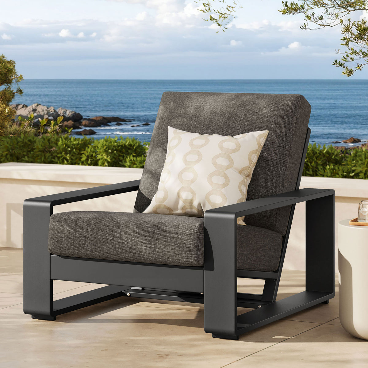 Smoke gray and charcoal outdoor armchair grounding a chic seating nook on a coastal patio || EEI-7300-SMO-GRY || front_angle_room