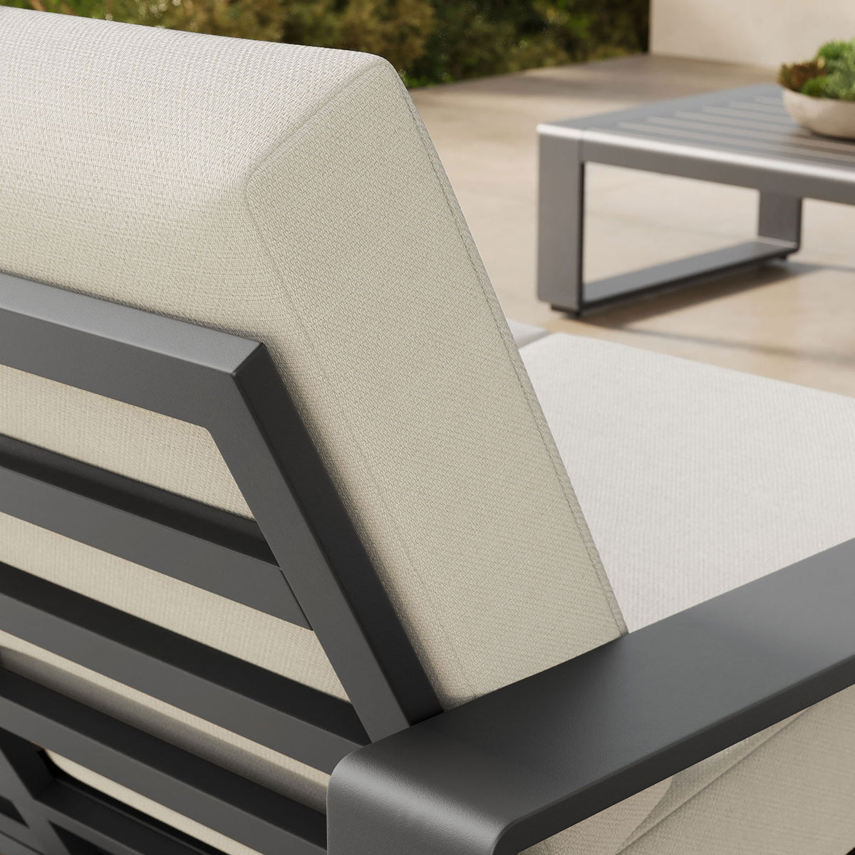 Cushion and arm detail reveals the cream fabric texture against the sleek charcoal aluminum frame || EEI-7301-CRE-GRY || detail_room