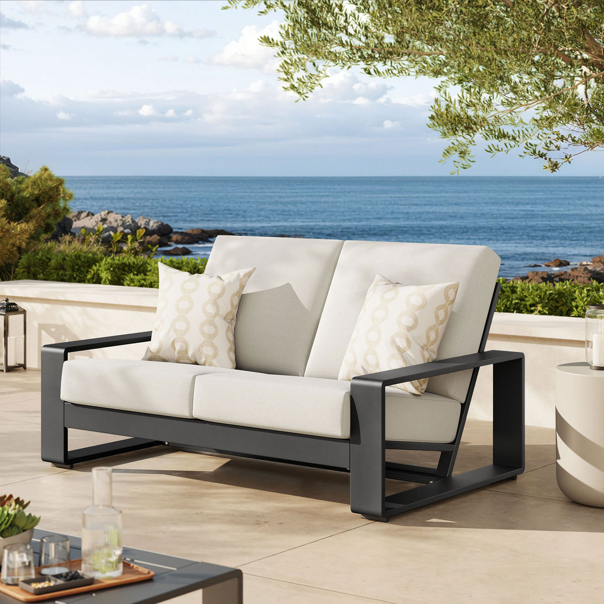 Cream cushions and charcoal frame create a relaxed outdoor seating centerpiece styled with coastal accents || EEI-7301-CRE-GRY || front_angle_room