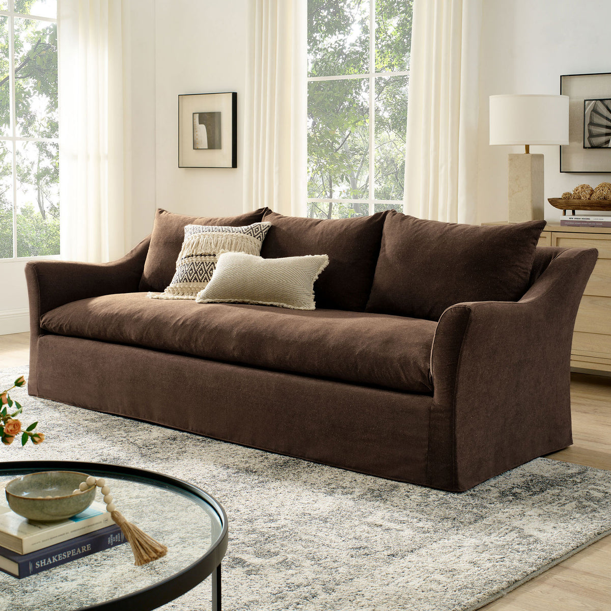 Cocoa Somerset slipcovered sofa anchored in a bright living room with rug, art, and modern decor accents || EEI-7310-COA || front_angle_room