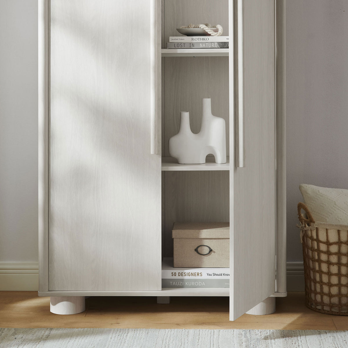 Styled Bellamy ash cabinet with open lower shelves displaying decor, books, and basket storage || EEI-7313-ASH || storage_open_room