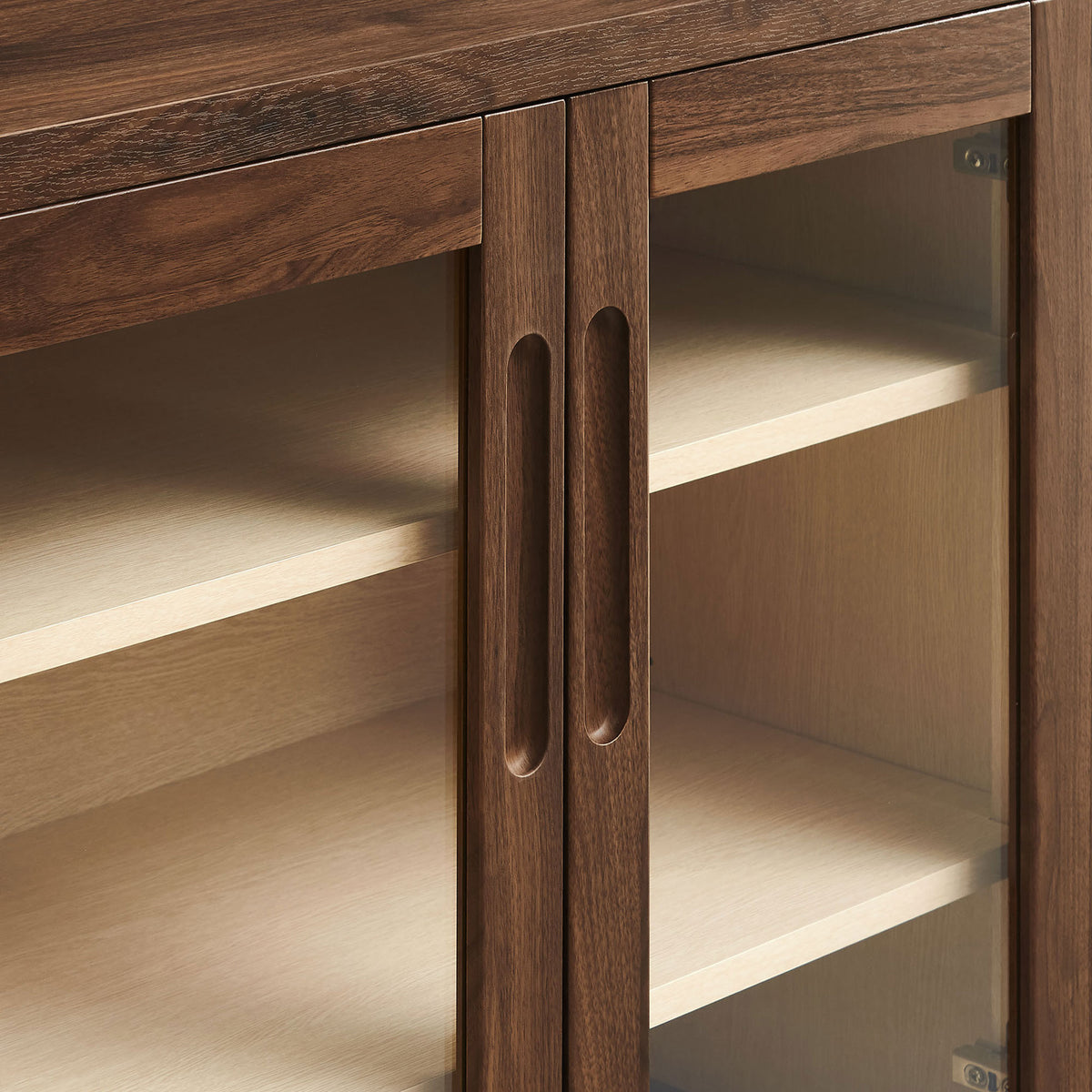 Finger-pull cutout handles and framed glass doors on the walnut Nell accent cabinet for a refined modern touch || EEI-7321-WAL-ASH || handle_studio