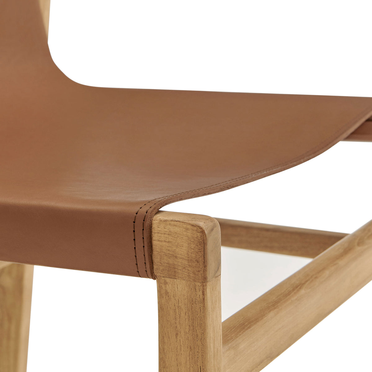 Smooth chestnut leather seat draped over solid teak frame with neat topstitching at the front edge || EEI-7326-CSN || detail_studio