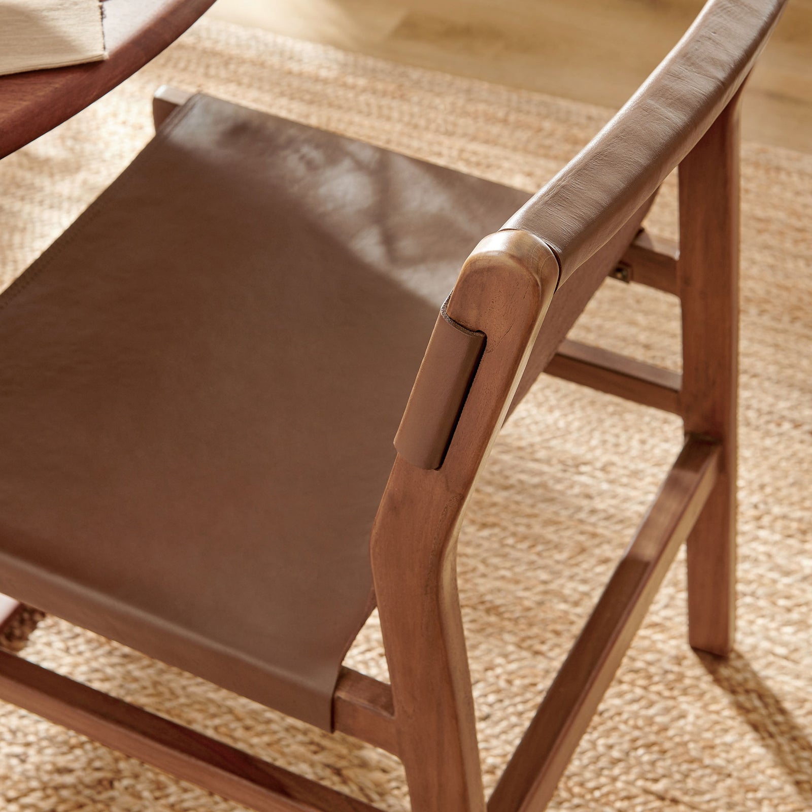 Leather sling seat and rounded teak back rail styled in a warm, light-filled dining space || EEI-7326-NUT || detail_room