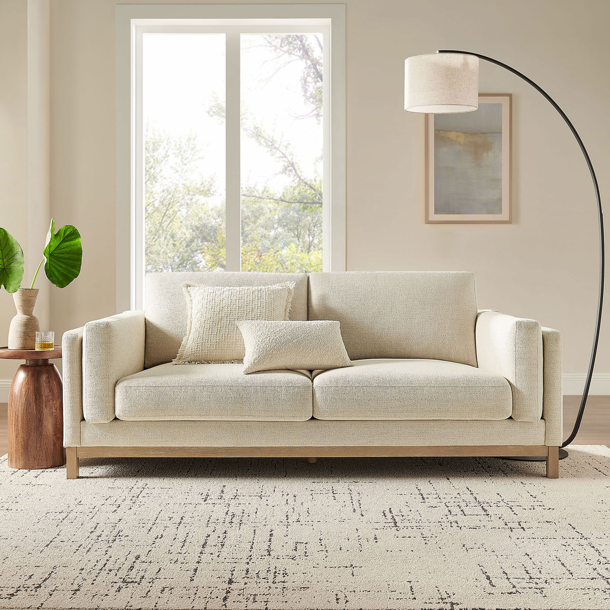 Roscoe ivory sofa in a living room setting with layered pillows, floor lamp, and textured area rug || EEI-7327-IVO || front_room
