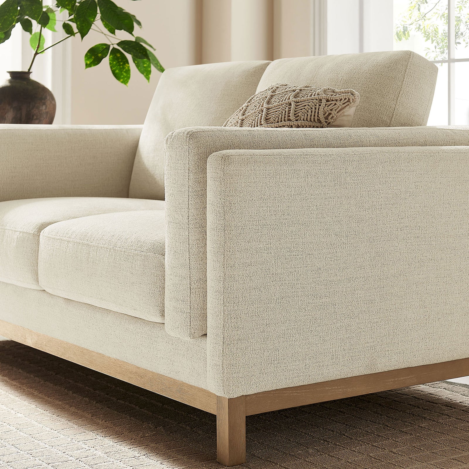 Ivory loveseat styled in a bright room with textured accent pillow and warm wood accents. || EEI-7328-IVO || detail_room