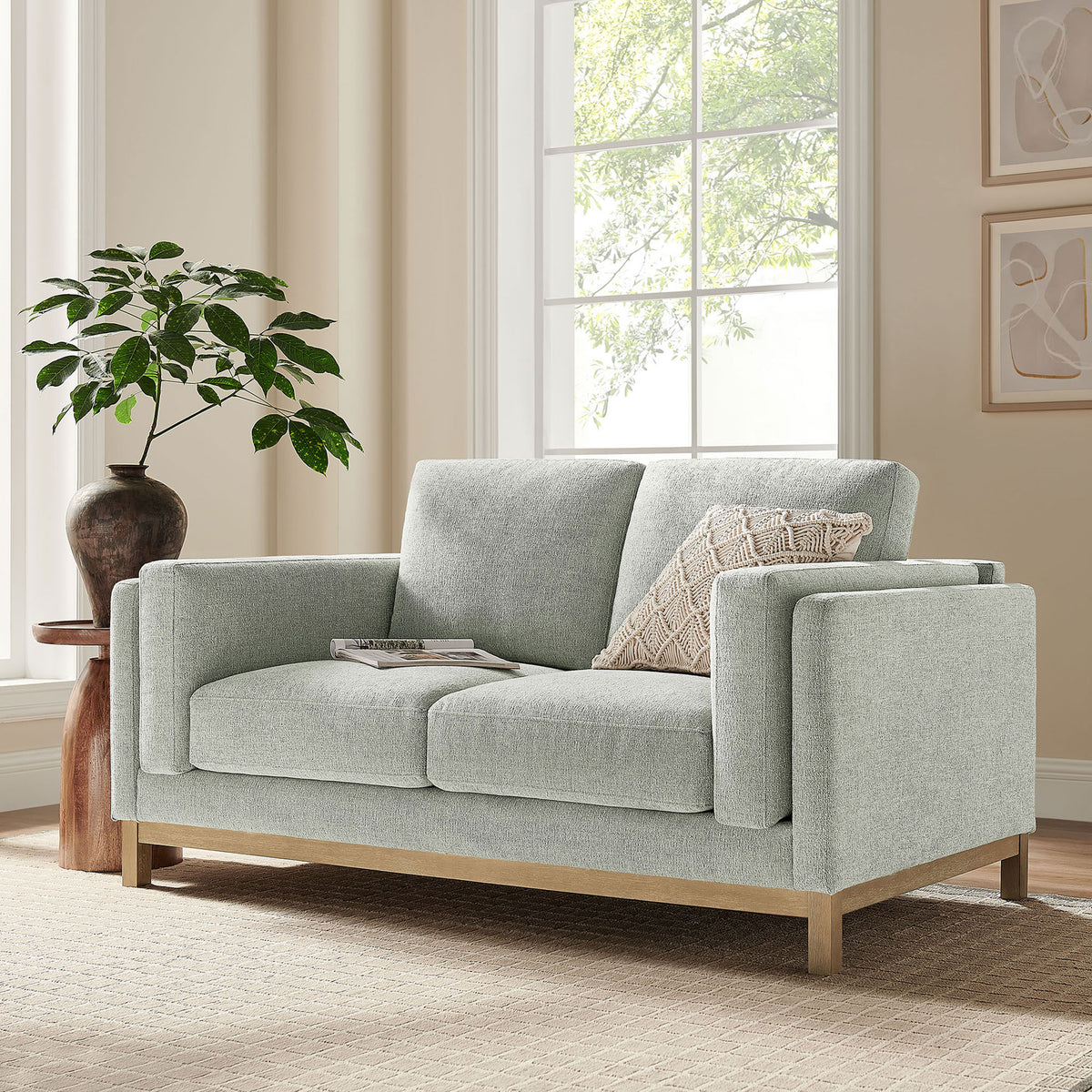 Mist loveseat styled in a bright living room with neutral rug, wood base, and textured accent pillow || EEI-7328-MST || front_angle_room