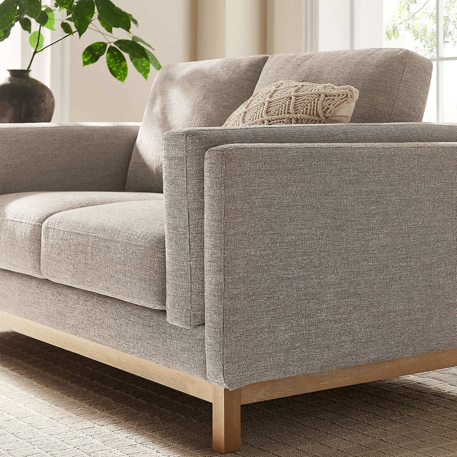 Pewter loveseat styled with a textured pillow, wood base, and soft natural light for a cozy feel. || EEI-7328-PEW || detail_room
