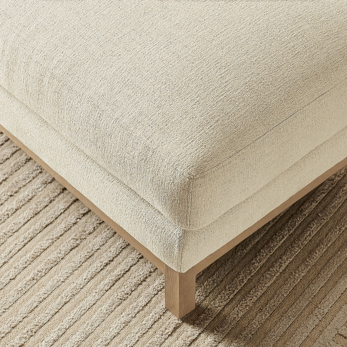 Textured ivory ottoman corner styled on a ribbed neutral area rug || EEI-7330-IVO || detail_room