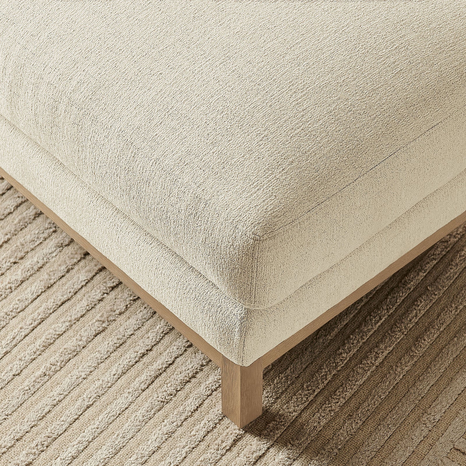 Textured ivory ottoman corner styled on a ribbed neutral area rug || EEI-7330-IVO || detail_room