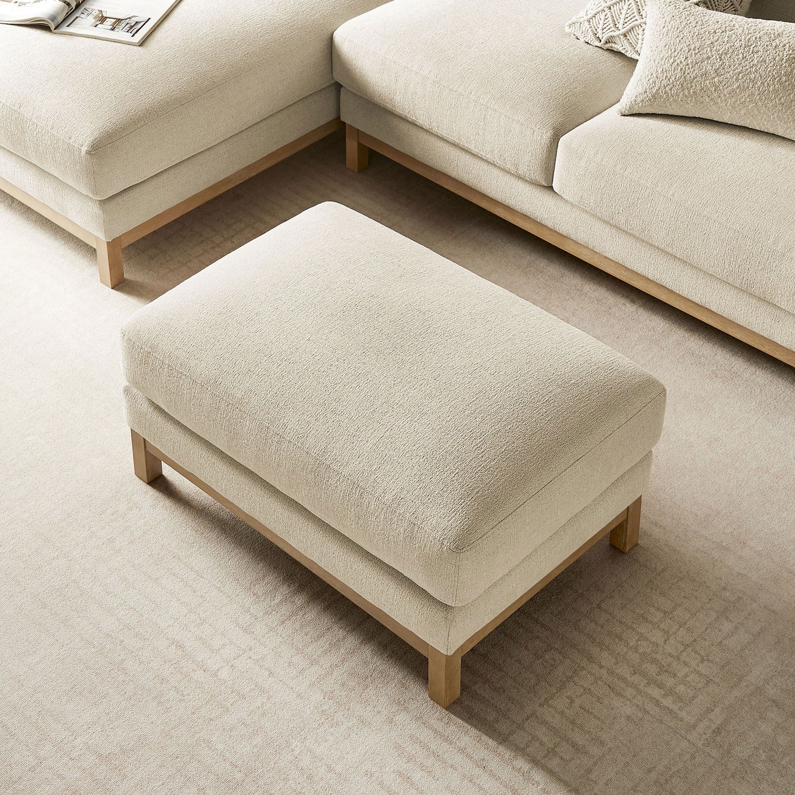 Ivory ottoman centered in lounge setup with coordinating modular seating || EEI-7330-IVO || top_angle_room