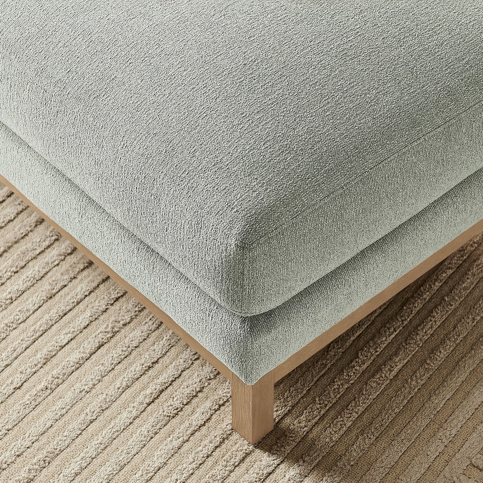 Mist chenille ottoman resting on a ribbed area rug, showing texture and relaxed modern style || EEI-7330-MST || detail_room