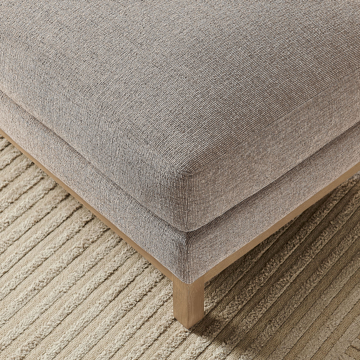 Close detail of the Roscoe ottoman cushion reveals soft chenille texture over a neutral area rug. || EEI-7330-PEW || detail_room