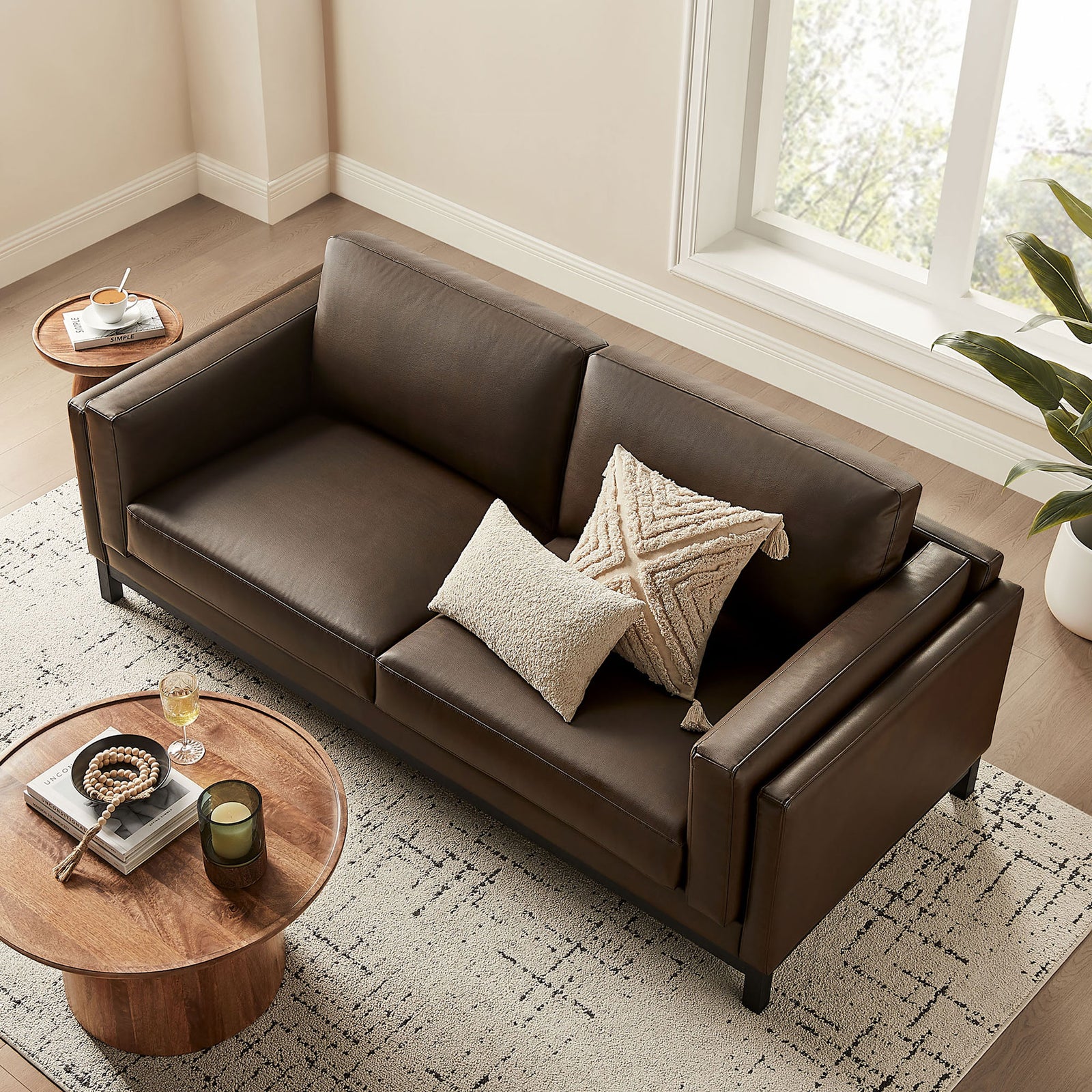 Roscoe sofa styled with throw pillows and coffee table accessories in a bright living room || EEI-7335-ESP || top_angle_room