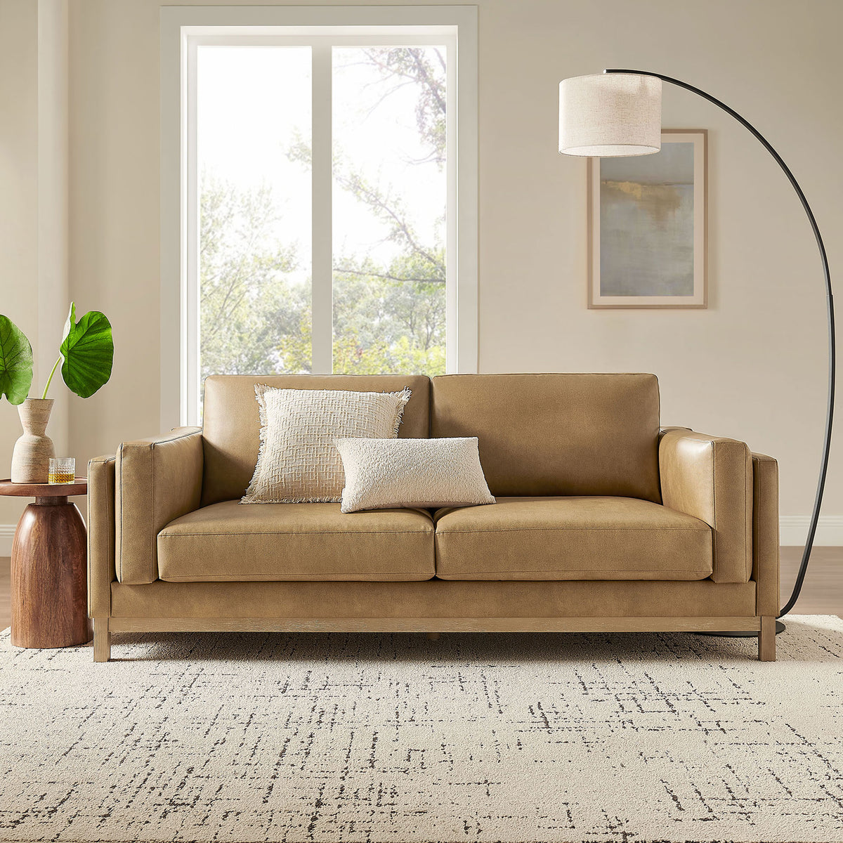 Roscoe toast vegan leather sofa styled in a cozy living room with layered pillows, rug, and floor lamp || EEI-7335-TST || front_room