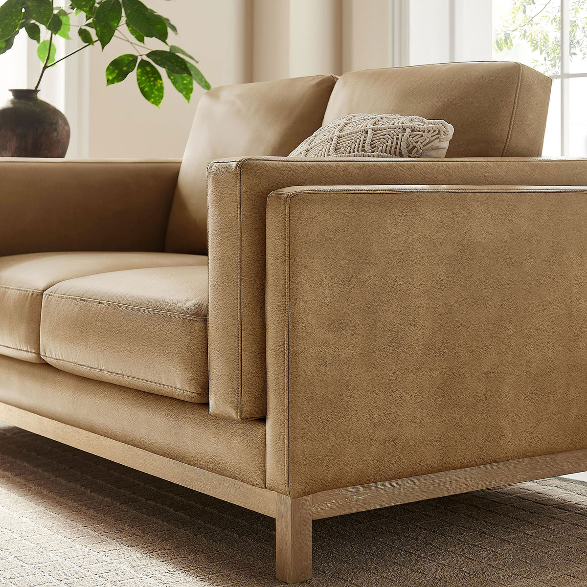 Textured accent pillow and warm toast vegan leather upholstery create a cozy look on this loveseat || EEI-7336-TST || detail_room