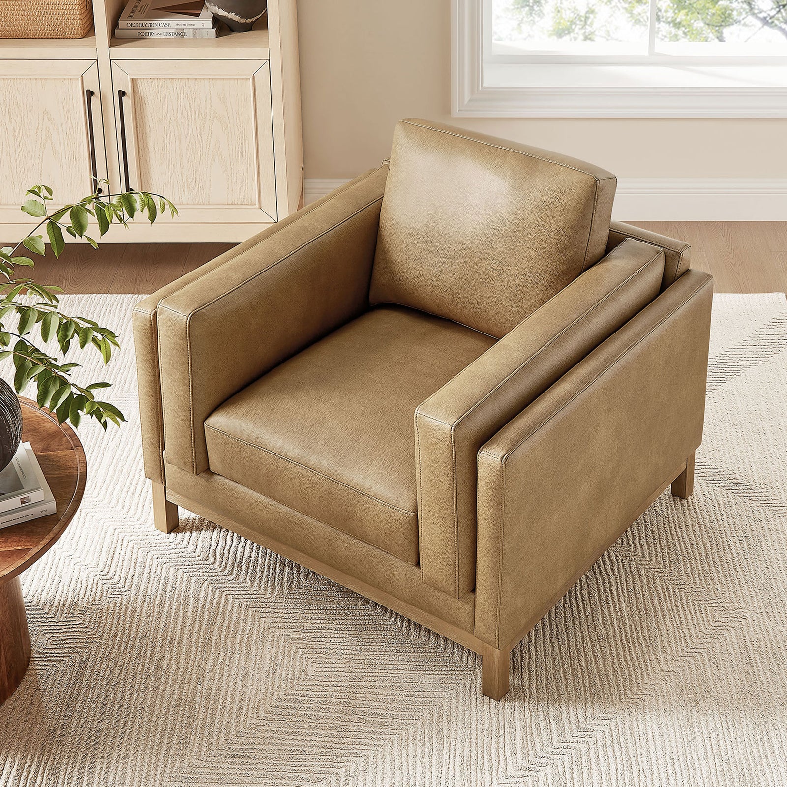 Plush seat and back cushions invite lounging, finished in soft toast vegan leather. || EEI-7337-TST || top_angle_room