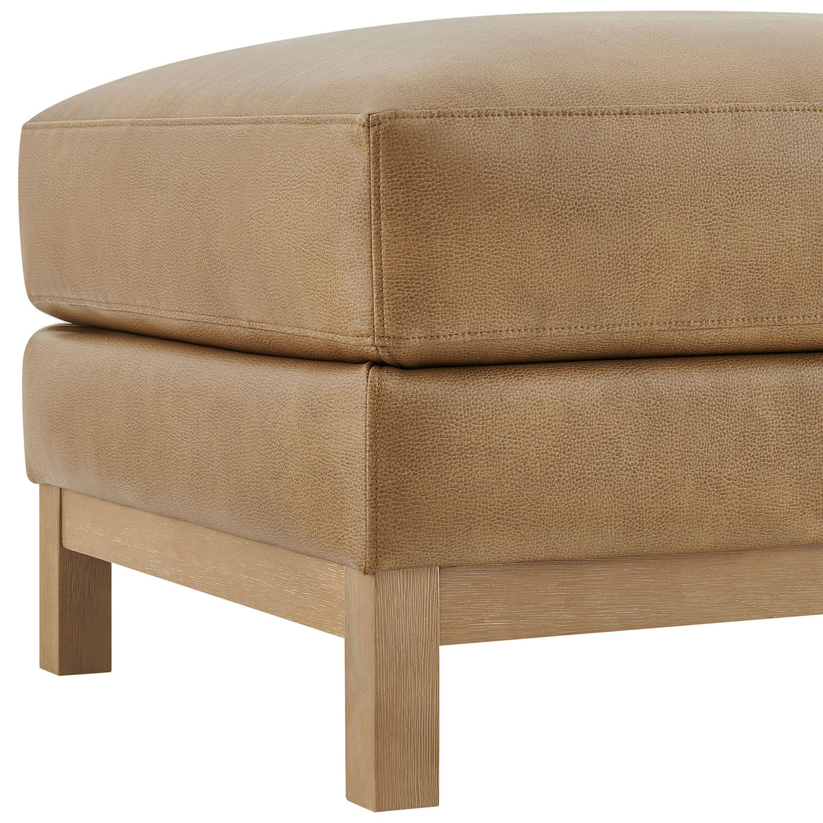 Stitched vegan leather upholstery and solid wood leg showcase the ottoman's refined craftsmanship || EEI-7338-TST || detail_studio