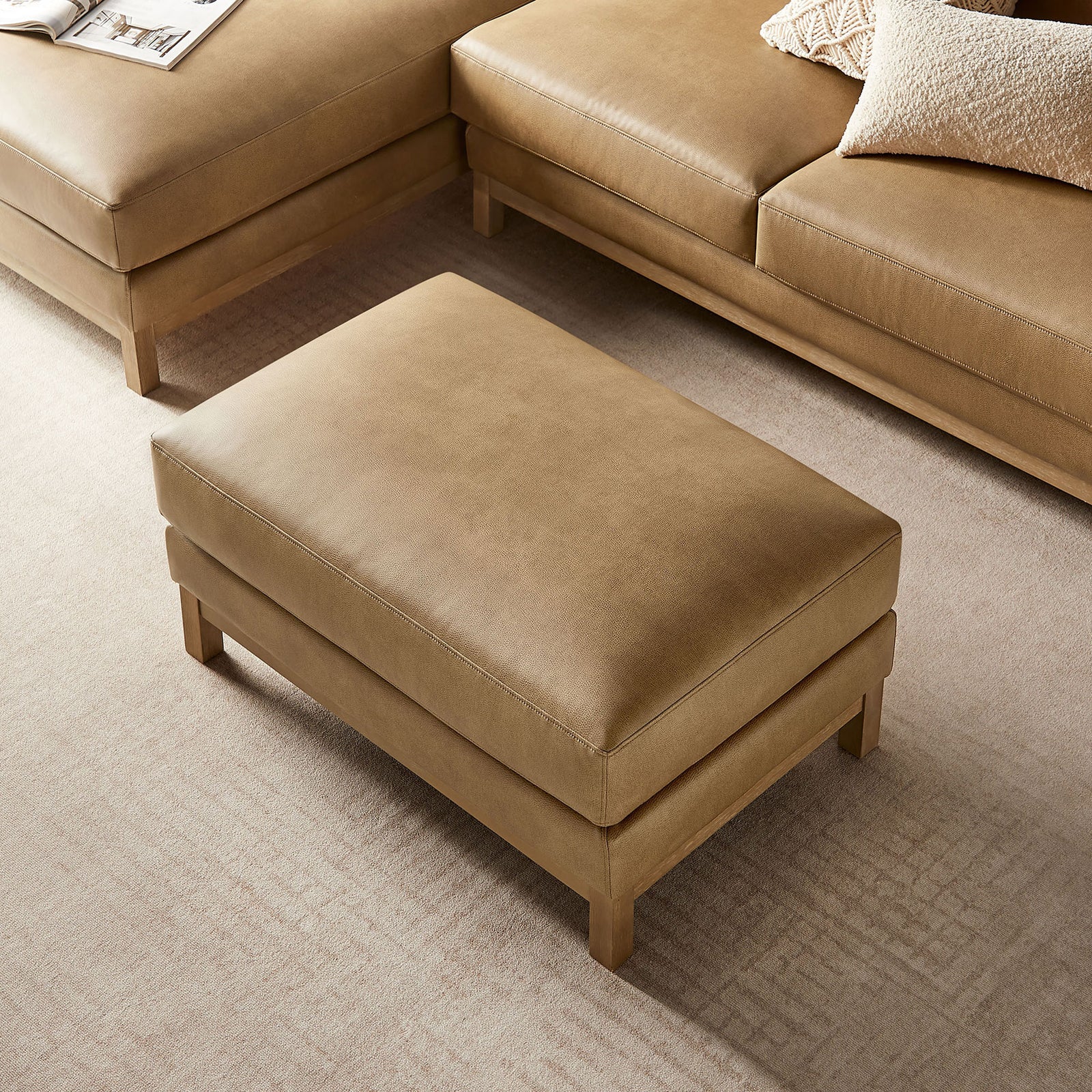 Ottoman used as a coffee table in a modern living room alongside matching vegan leather seating || EEI-7338-TST || top_angle_room