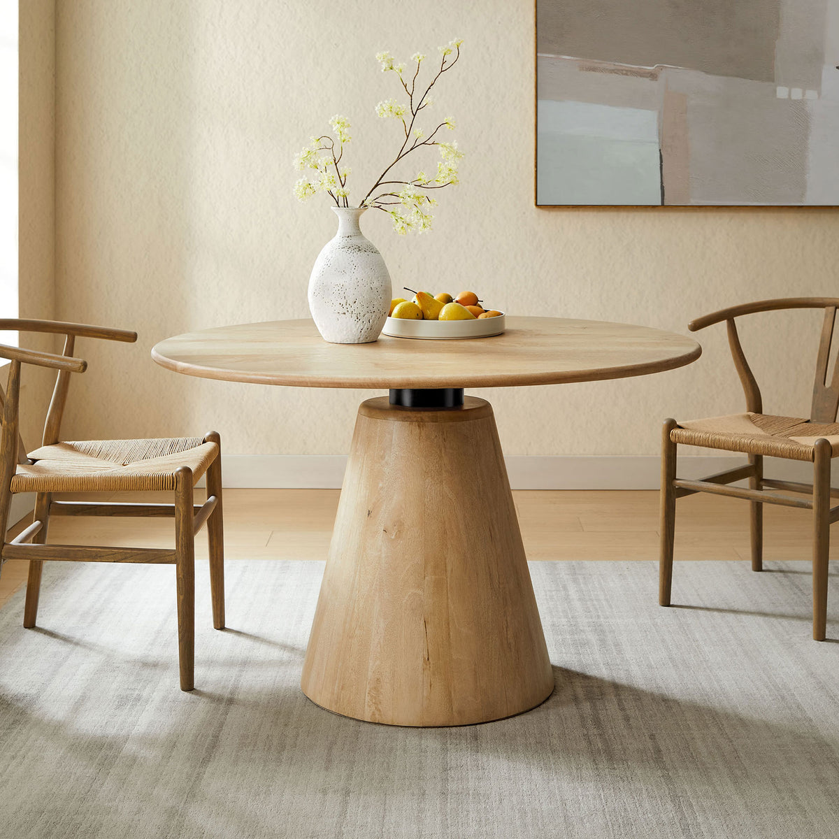Round mango wood dining table styled in a modern dining room with four woven seat chairs. || EEI-7343-NAT || front_angle_room