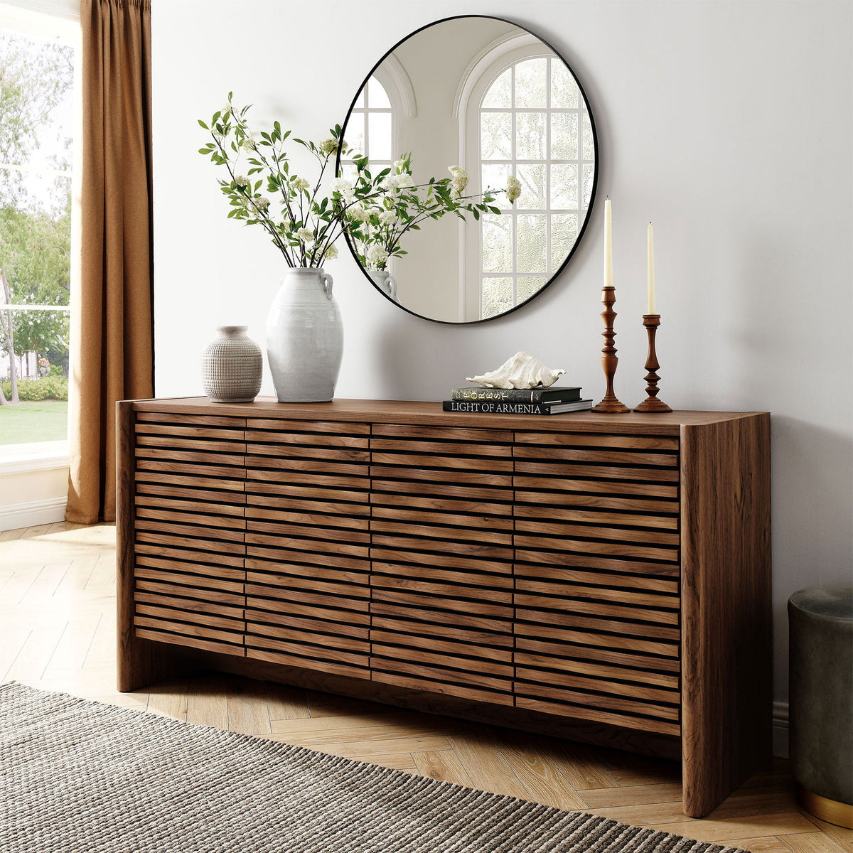 Walnut wave-front sideboard styled with vases and candles, adding warmth and texture to a bright living space || EEI-7346-WAL || front_angle_room