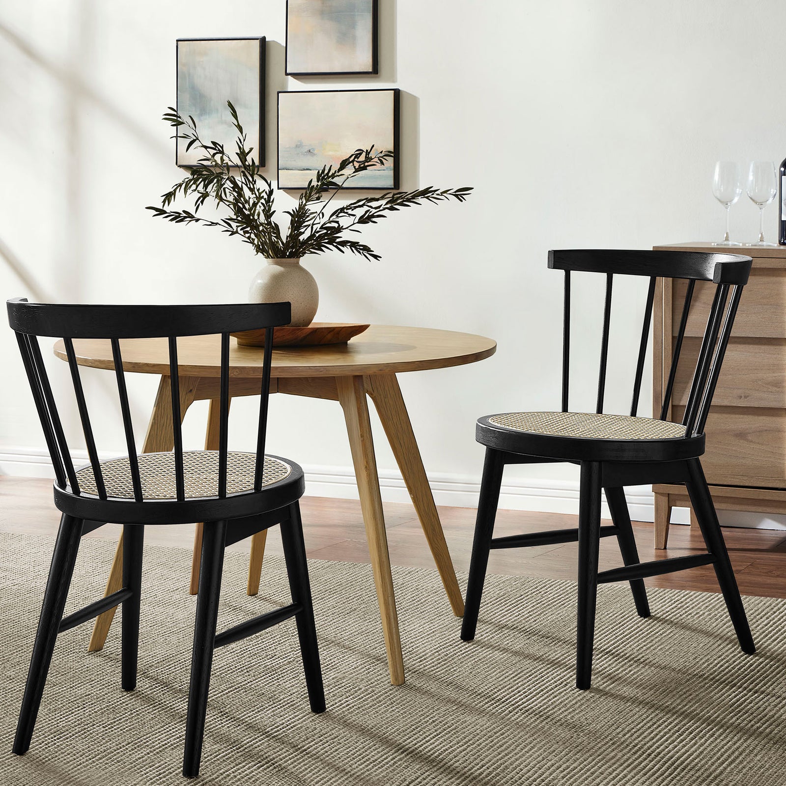 Pair of black cane seat dining chairs styled with a round wood table for a cozy modern dining nook || EEI-7350-BLK || front_angle_multi_room