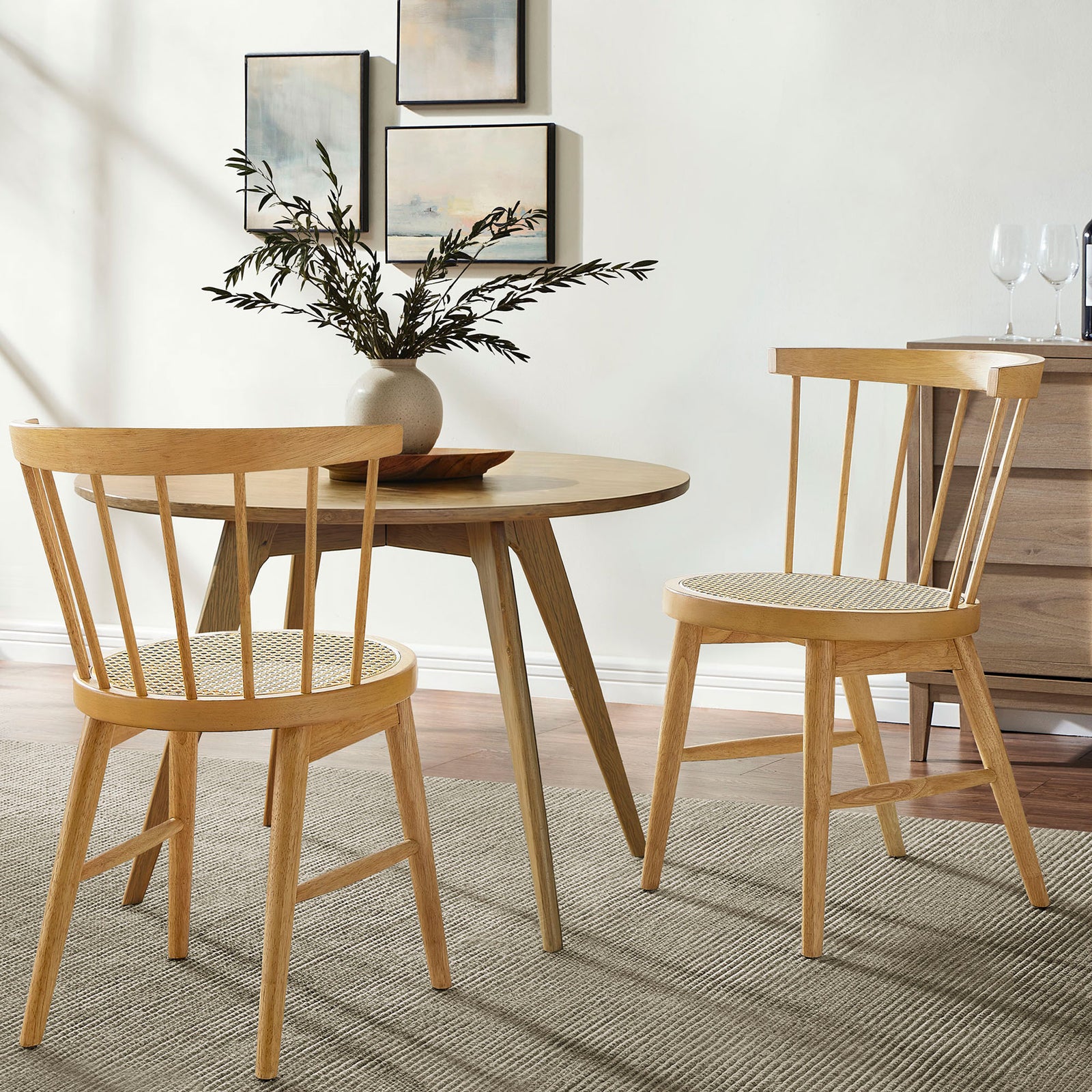Two natural wood Lykke chairs gather around a round table, bringing airy spindle-back style to a cozy dining nook || EEI-7350-NAT || front_angle_multi_room