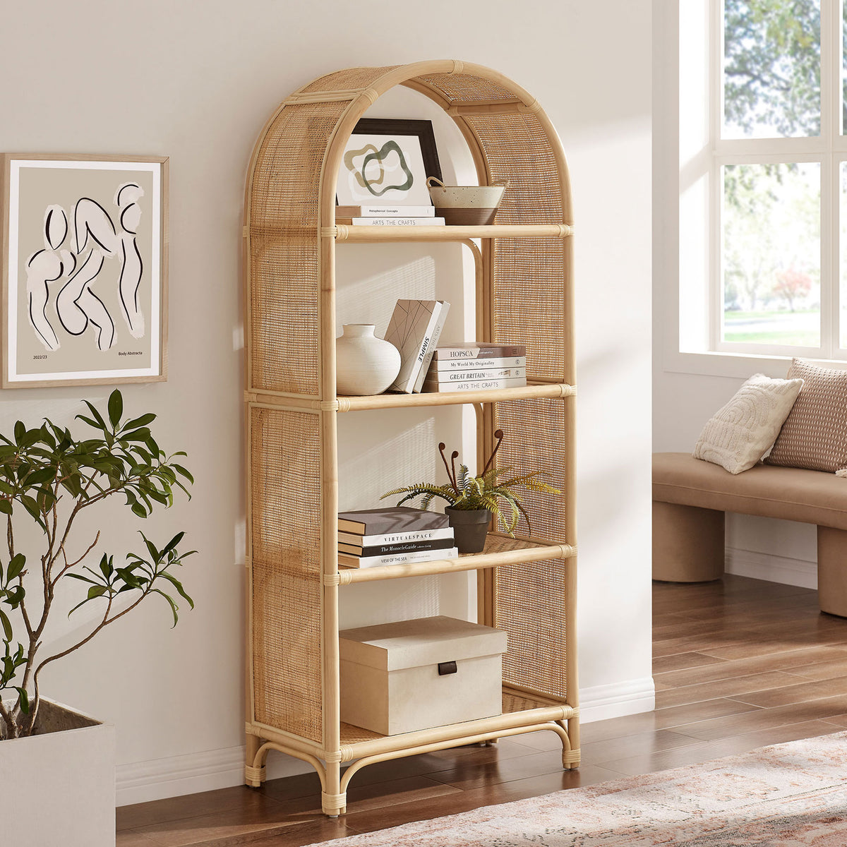 Tall arched rattan bookcase brings organic warmth and open shelving to a modern room. || EEI-7363-NAT || front_angle_room
