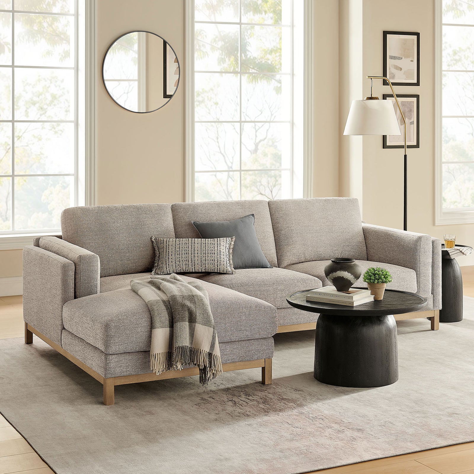 Left-facing Roscoe sectional styled in a bright living room with soft rug, round table, and accent decor. || EEI-7374-PEW || front_angle_room