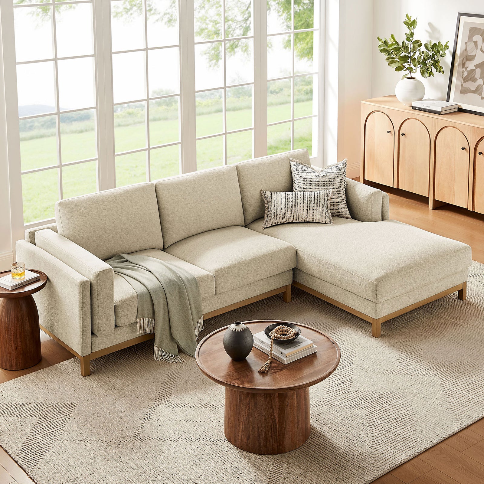 Right-facing ivory sectional with chaise dressed in soft throws and pillows before expansive windows and warm storage || EEI-7375-IVO || front_angle_room