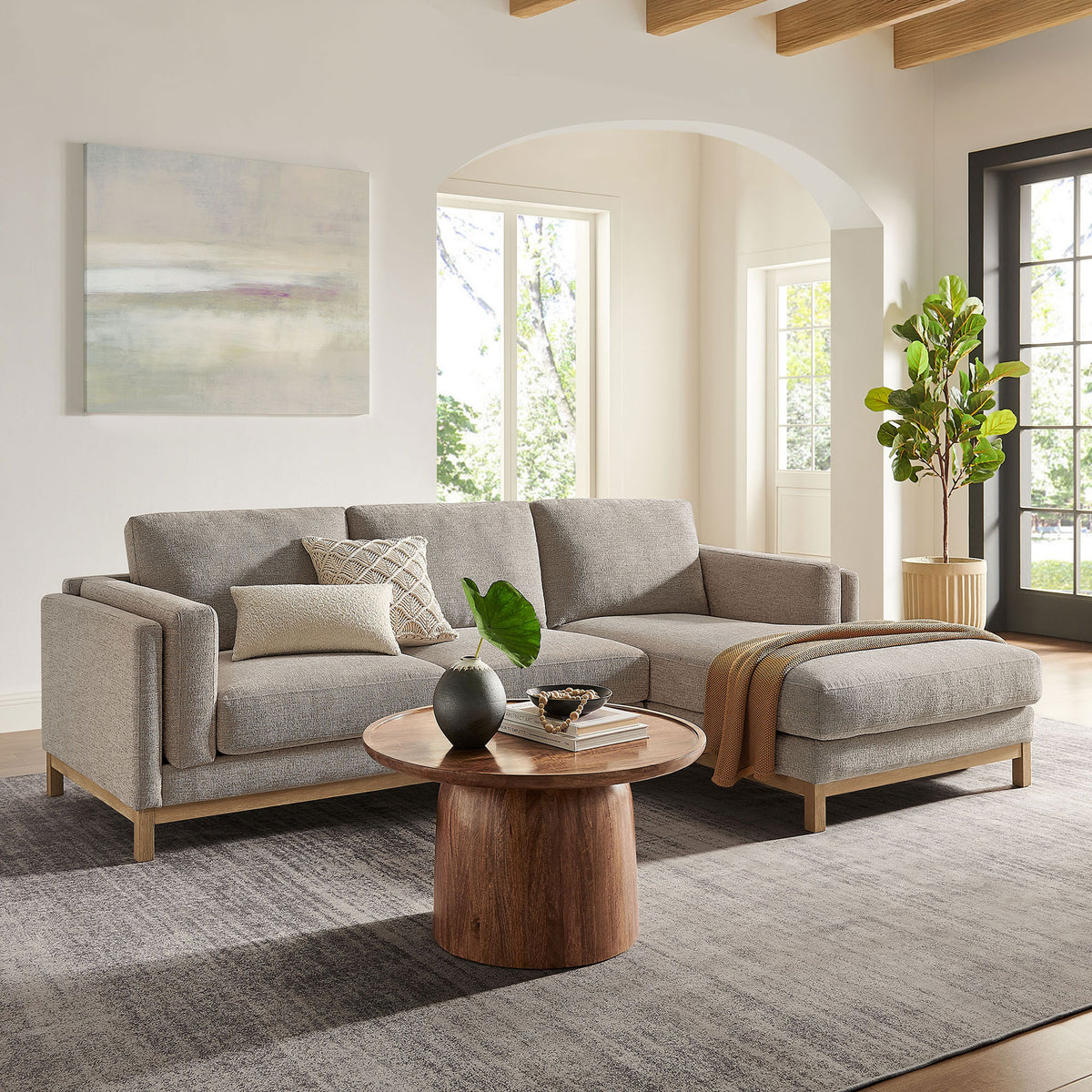 Right-facing Roscoe sectional arranged in a bright living room with warm wood accents and layered textiles. || EEI-7375-PEW || front_angle_room