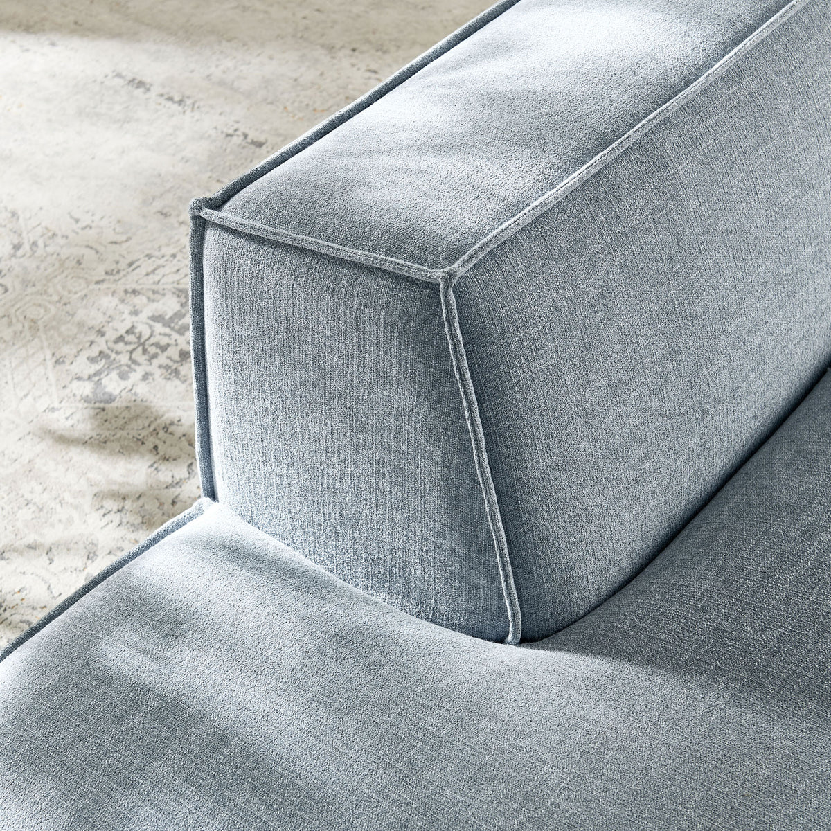 Textured weave and crisp piping add refined detail to this sky blue modular chaise || EEI-7386-SKY || detail_room