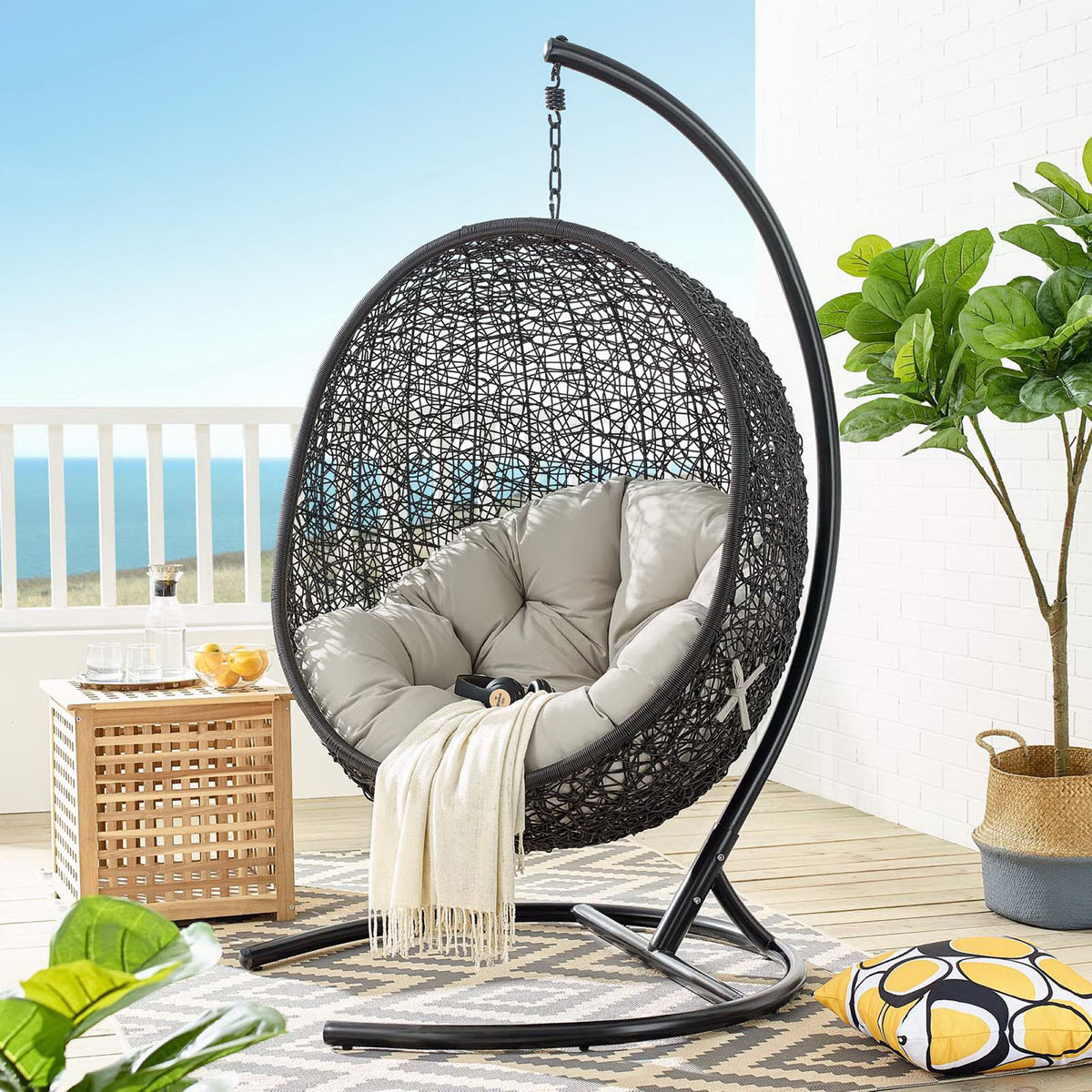 Beige cushioned egg chair with stand creates a relaxing focal point on the coastal patio || EEI-739-BEI-SET || front_angle_room