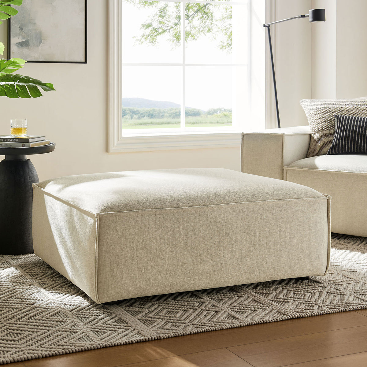 Restore ecru modular ottoman anchors a bright living room with coordinating sofa, rug, and decor. || EEI-7401-ECR || front_angle_room