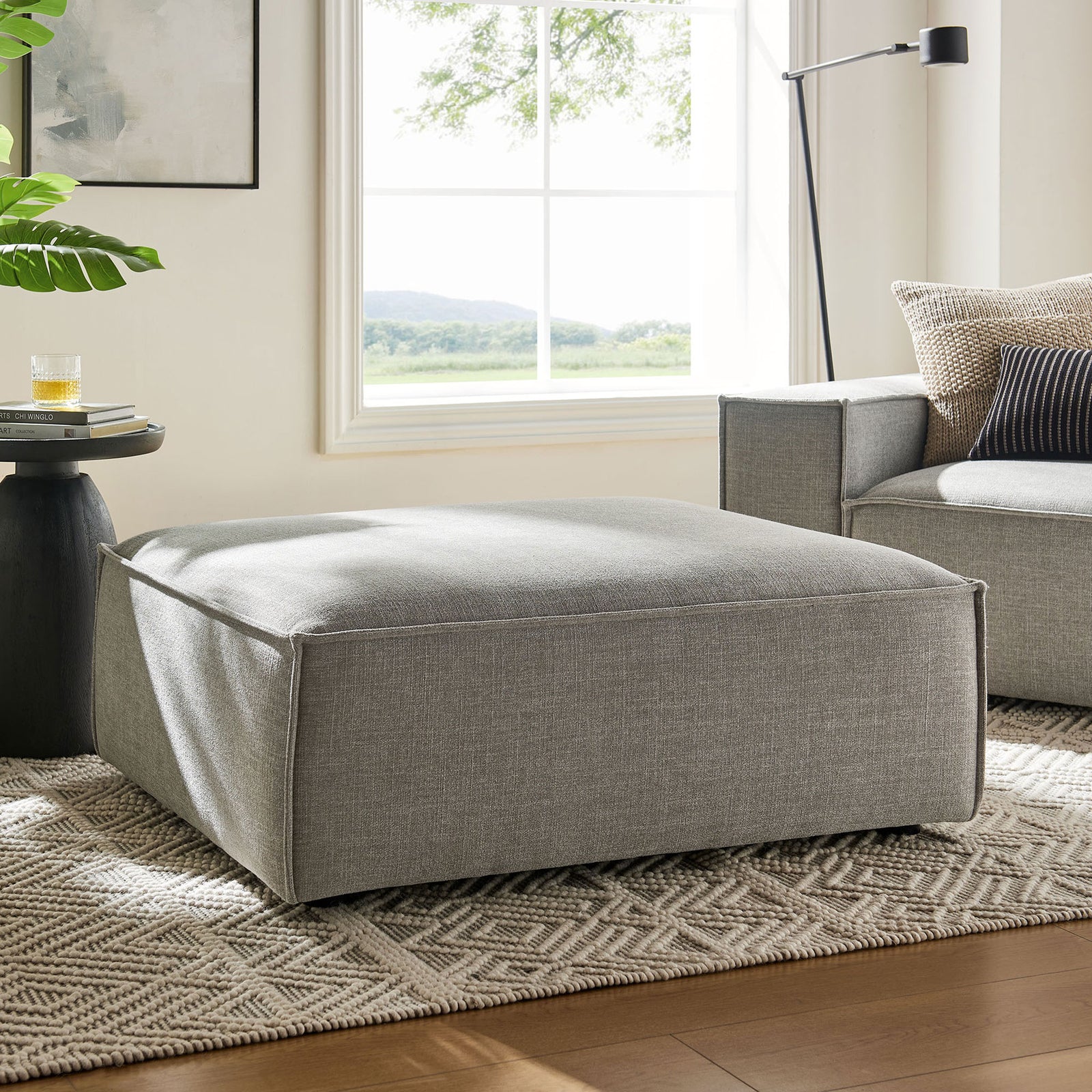 Pewter modular ottoman anchoring a relaxed living room beside a matching sofa on a textured neutral rug || EEI-7401-PEW || front_angle_room