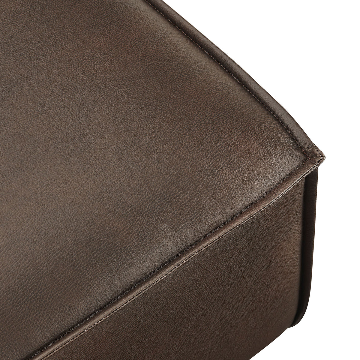 Rich espresso vegan leather showcases subtle grain and refined stitching along the ottoman edge. || EEI-7402-ESP || detail_studio