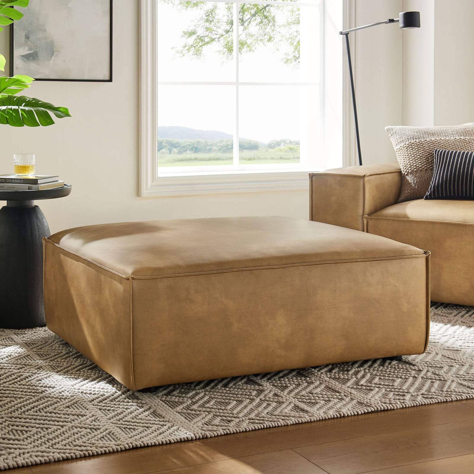 Spacious modular ottoman anchors a bright living room with matching seating and modern decor || EEI-7402-TST || front_angle_room