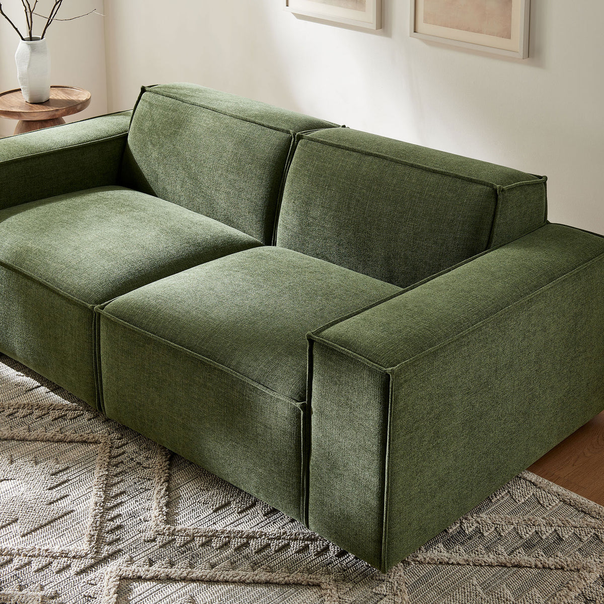 Modern foliage green modular loveseat styled in a bright living room with neutral decor and greenery. || EEI-7403-FOL || front_angle_room